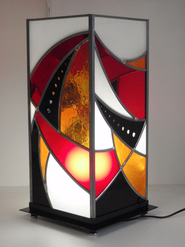 lampe en vitrail avec une pièce centrale métallique percée et verres colorés