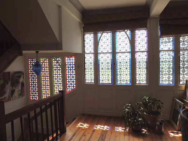 ensemble de vitraux géométriques restaurés dans un salon